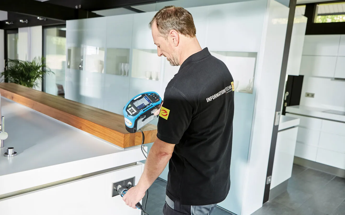E-CHECK - Mitarbeiter prüft die Steckdosen in der Küche · Finke Elektro