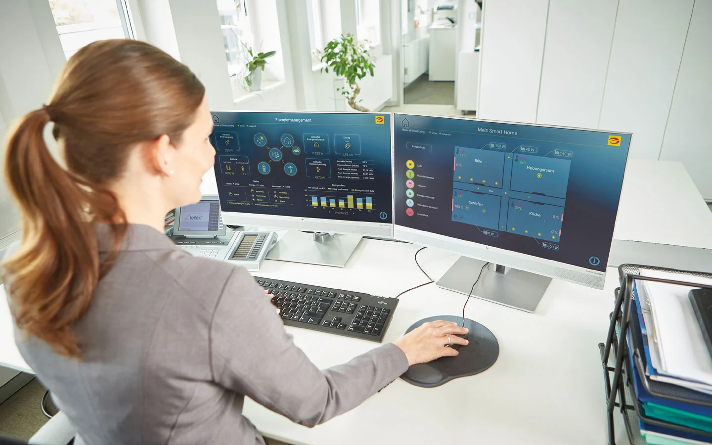 E-CHECK IT - Mitarbeiterin überprüft an Monitoren die IT-Systeme · Finke Elektro