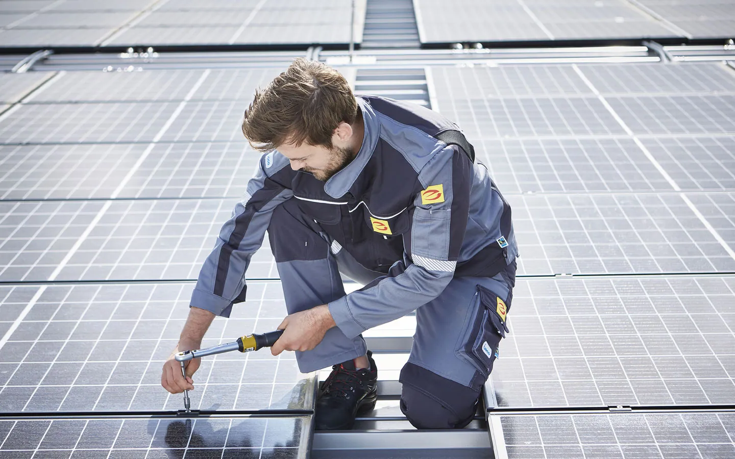 E-CHECK E-Mobilität - Mitarbeiter montiert auf dem Dach die neuen Solarmodule · Finke Elektro